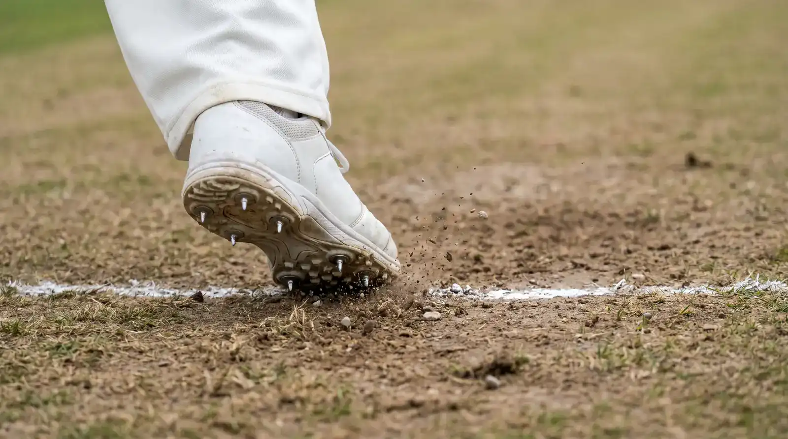 Close-up of bowler's front foot landing just behind the popping crease during delivery