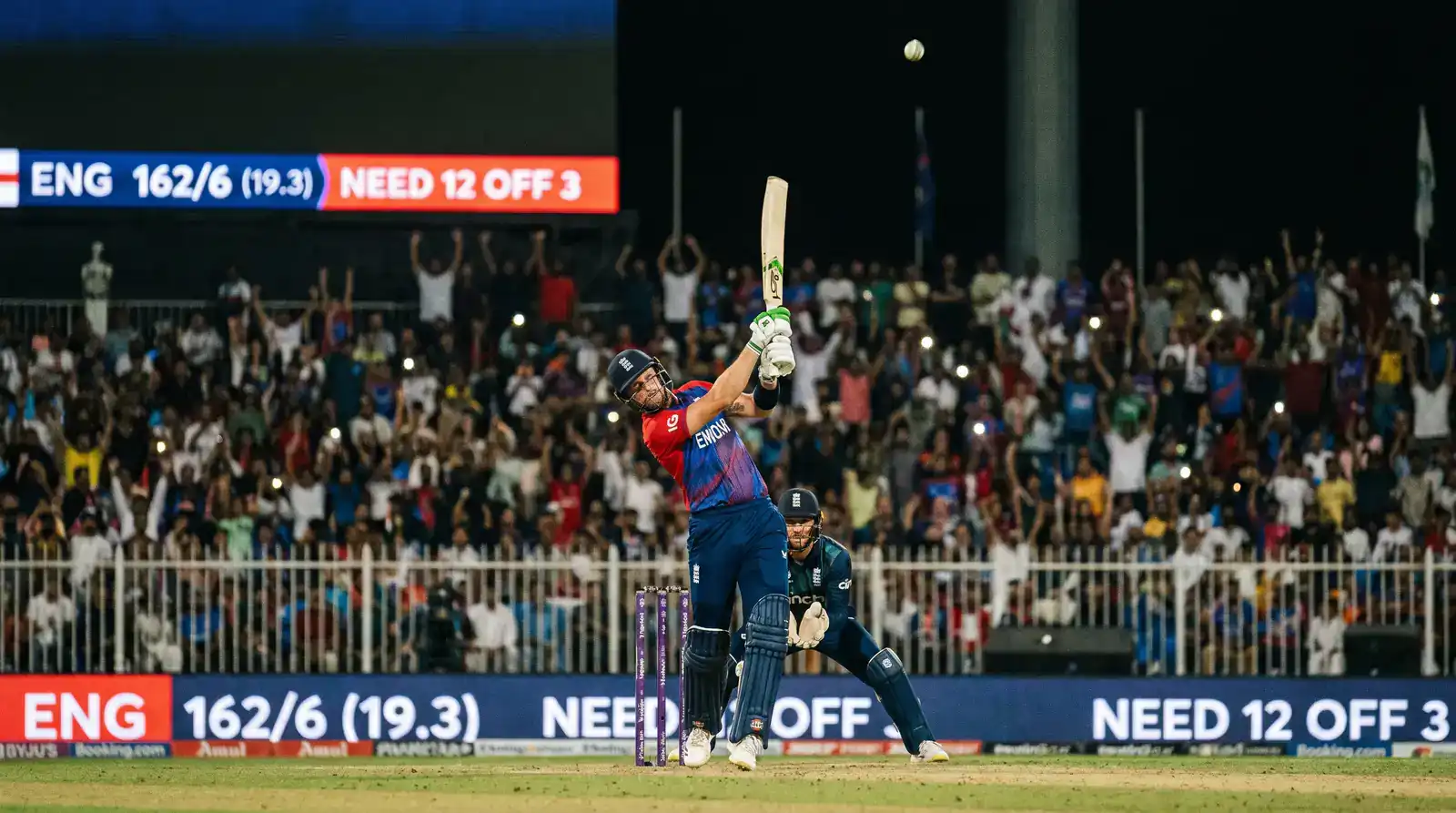 T20 batter playing an aggressive scoop over the wicket-keeper for a boundary during the death overs