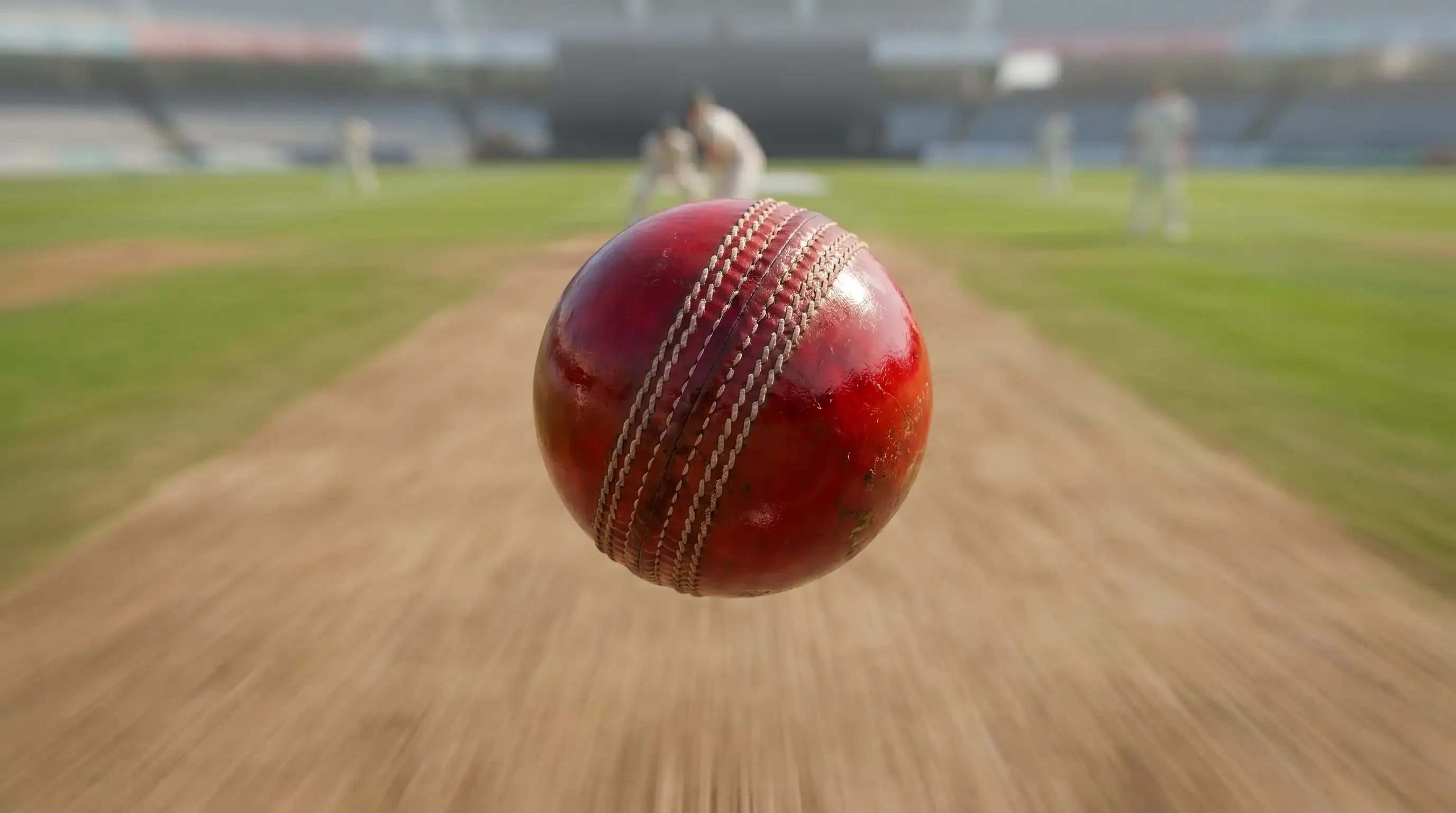 Cricket ball mid-flight just after release captured against the pitch with sharp focus on the seam position