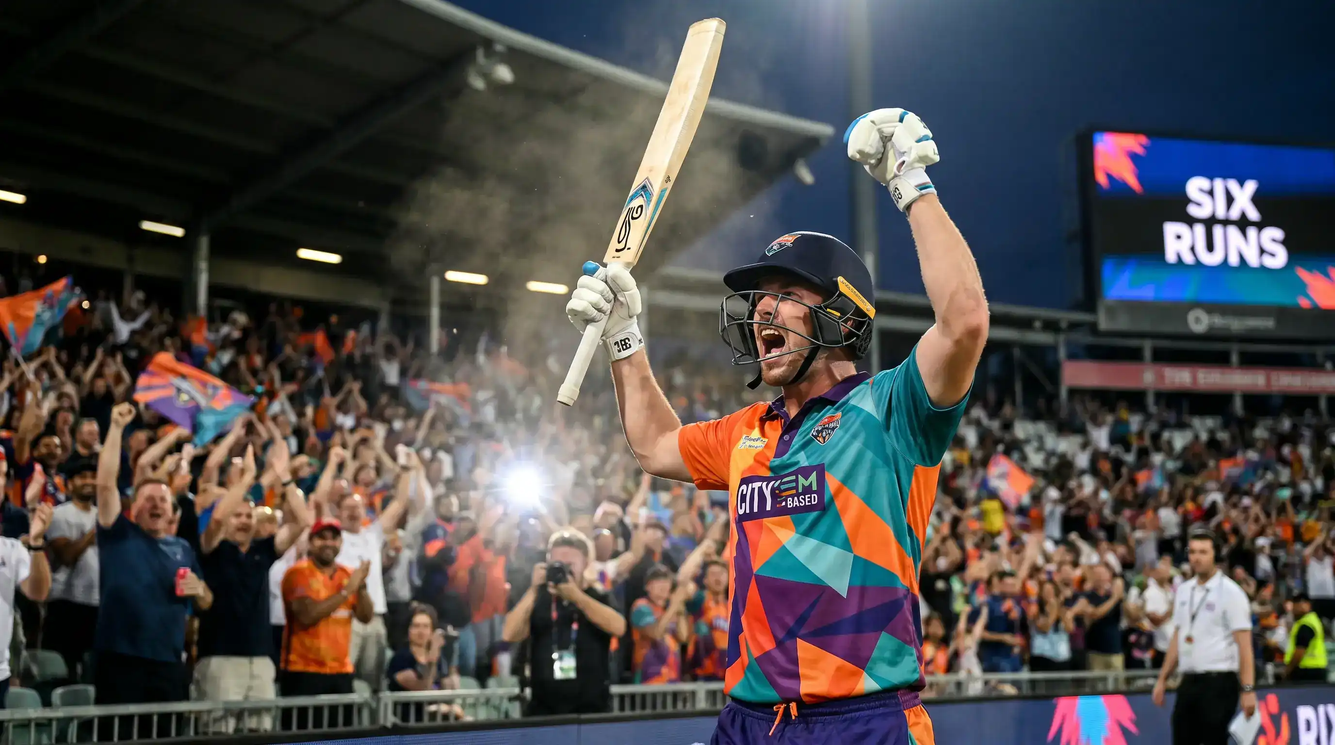 Cricket batter celebrating a six with arms raised as the crowd jumps to their feet in the stands behind