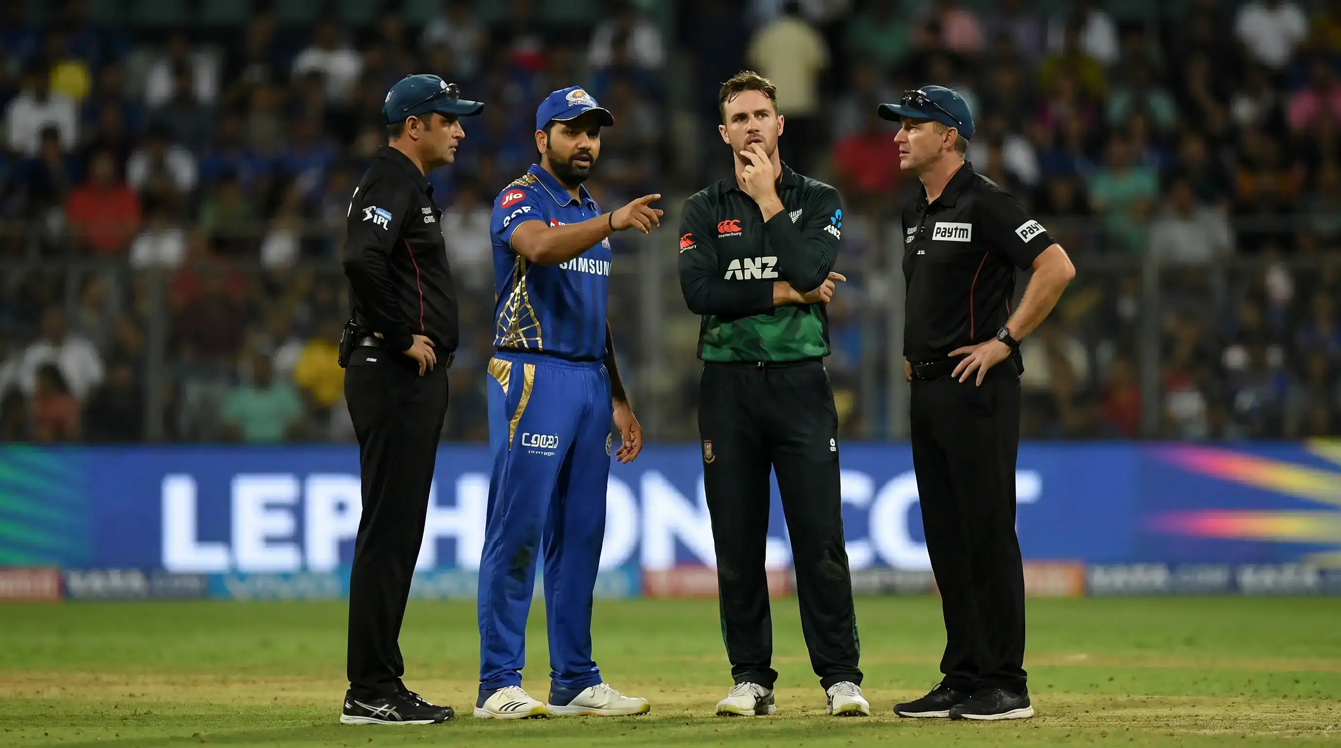 Two cricket captains and umpires discussing arrangements at the boundary between consecutive super overs in a tied chase