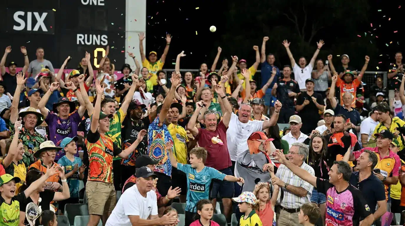 Hundred match crowd cheering and waving as a six is struck, with the stadium full to capacity